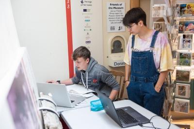 Photo of two young people looking at a computer screen